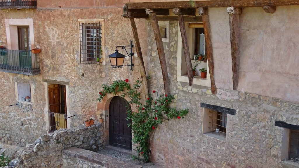 Stoned old house in Albarracín (Teruel, Spain) with a rose surrounding the door.